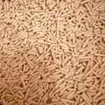 A detailed top view of a large pile of wood pellets used for renewable fuel and energy.