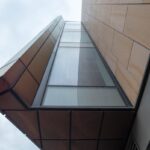 A striking view of contemporary architecture capturing geometric shapes and glass facade from below.