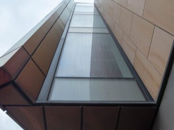 A striking view of contemporary architecture capturing geometric shapes and glass facade from below.