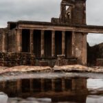 Explore the historic ruins of Pompeii with stunning column architecture reflected in a puddle.