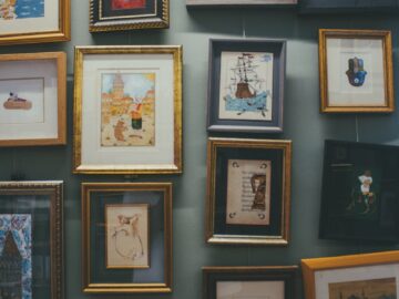 Collection of framed art and illustrations displayed on a gallery wall.