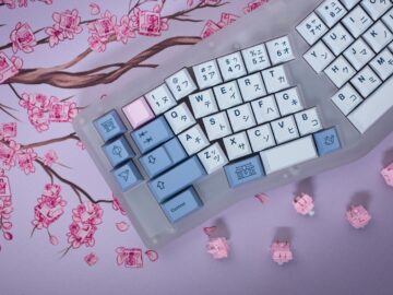 Aesthetic mechanical keyboard with Japanese keycaps on cherry blossom design mat, providing a modern tech twist.