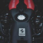 Focused view of a red Ferrari engine showcasing automotive engineering and power.