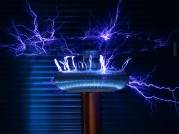 A Tesla coil producing powerful electric arcs in a dark setting.