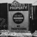 Monochrome photo of a private property sign with 'Do Not Enter' message.