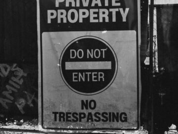 Monochrome photo of a private property sign with 'Do Not Enter' message.