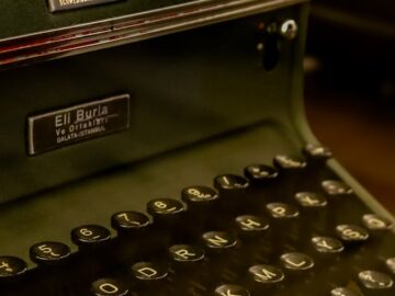 Close-up of a vintage Halda typewriter with a dark green finish, showcasing nostalgic charm.