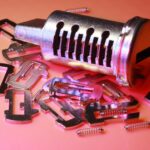 Detailed image of a disassembled lock cylinder and its metal components on a colored surface.