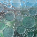 Close-up macro photo of oil bubbles on a water surface creating an abstract pattern.