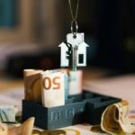 House key over Euro banknotes symbolizes real estate investment and financial planning.