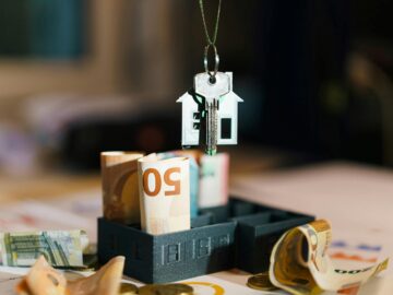 House key over Euro banknotes symbolizes real estate investment and financial planning.