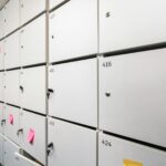 Row of white lockers with colorful sticky notes and numbers, ideal for office organizing theme.