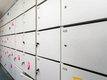 Row of white lockers with colorful sticky notes and numbers, ideal for office organizing theme.