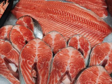 Close-up of fresh salmon fillets and steaks on ice, perfect for culinary presentations.