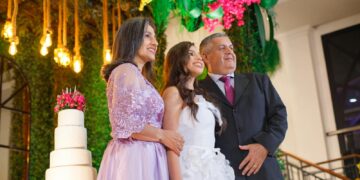 A joyful family portrait at a wedding with a beautifully decorated cake.