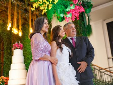 A joyful family portrait at a wedding with a beautifully decorated cake.