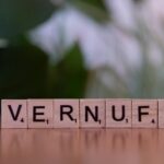 Close-up of Scrabble tiles arranged to spell 'Vernuft' on a wooden surface with blurred background.