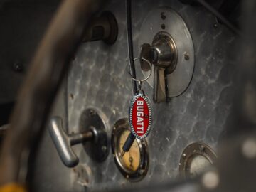 Close-up of a vintage Bugatti car interior featuring the key in the ignition. Captures classic automotive design.