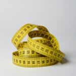 A close-up image of a coiled yellow measuring tape displaying numbers clearly.