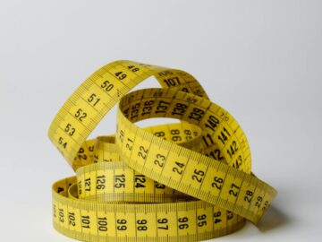 A close-up image of a coiled yellow measuring tape displaying numbers clearly.