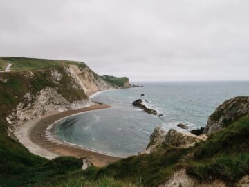 Explore the scenic beauty of Durdle Door's cliffs and beach on a summer day.