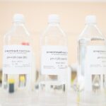 Clear bottles of buffer solution with pH labels in a laboratory setting.