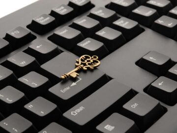 Close-up of an ornate vintage key placed on a modern computer keyboard.