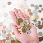 Close-up of a hand holding diverse coins, symbolizing global currency and finance.