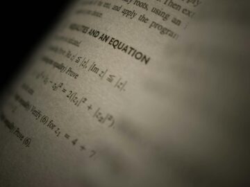 Selective focus on a mathematics textbook page with complex equations and text.