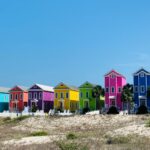 Colorful row of beach houses under a clear blue sky on Saint George Island, Florida.