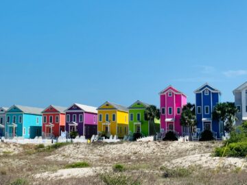 Colorful row of beach houses under a clear blue sky on Saint George Island, Florida.
