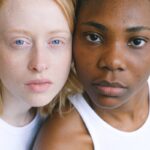 Close-up portrait capturing diversity and unity between two women of different ethnicities.