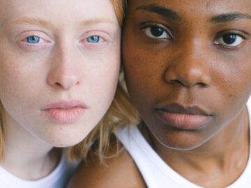 Close-up portrait capturing diversity and unity between two women of different ethnicities.