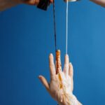 Abstract photo of hands pouring liquids against a blue background.
