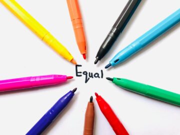 Colorful markers arranged in a circle on white paper around the word 'Equal'.