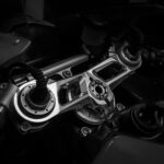 Detailed black and white image of a motorcycle's handlebar mechanism showcasing its gear and technology.