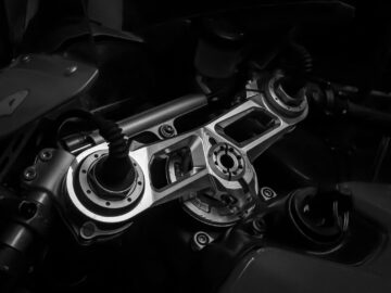 Detailed black and white image of a motorcycle's handlebar mechanism showcasing its gear and technology.