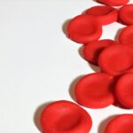 Artistic depiction of red blood cells on a white background, emphasizing medical concepts.