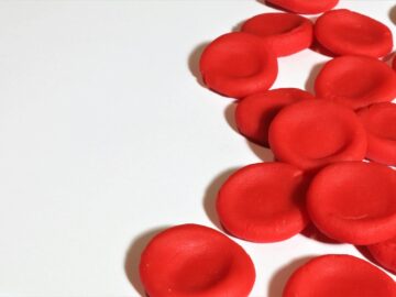 Artistic depiction of red blood cells on a white background, emphasizing medical concepts.