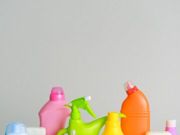 Assorted colorful plastic cleaning bottles on a white background.