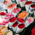 From above set of various colorful bouquets of roses wrapped in paper in florist shop