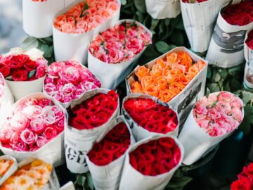 From above set of various colorful bouquets of roses wrapped in paper in florist shop