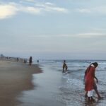 People enjoying a calm evening walk on Chennai's picturesque beachfront.