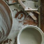 Close-up of clay tools and pottery wheel in a workshop setting, perfect for art enthusiasts.