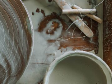 Close-up of clay tools and pottery wheel in a workshop setting, perfect for art enthusiasts.