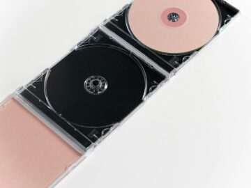 Artistic flat lay of open CD cases on a white surface, showcasing compact discs.