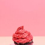 Mouth-watering red velvet cupcake with pink cream frosting, perfect for celebrations.