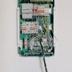 Detailed view of an open electrical circuit box with complex wiring and circuit breakers.