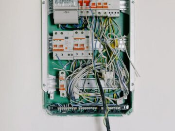Detailed view of an open electrical circuit box with complex wiring and circuit breakers.