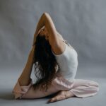 Woman practicing yoga in a serene studio setting, showcasing flexibility and wellness.